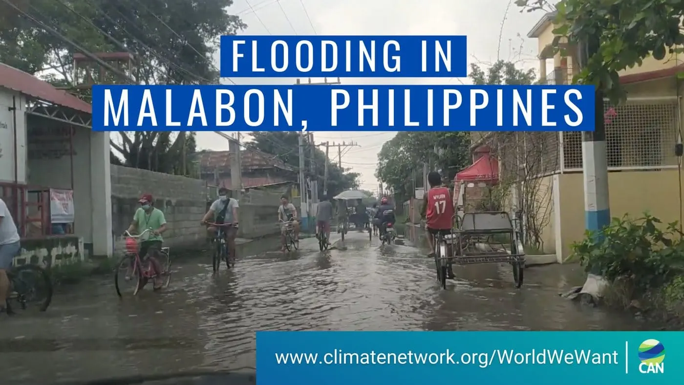 Campaign card reading “Flooding in Malabon, Philippines”, over footage of cyclists and tricycles crossing a flooded street