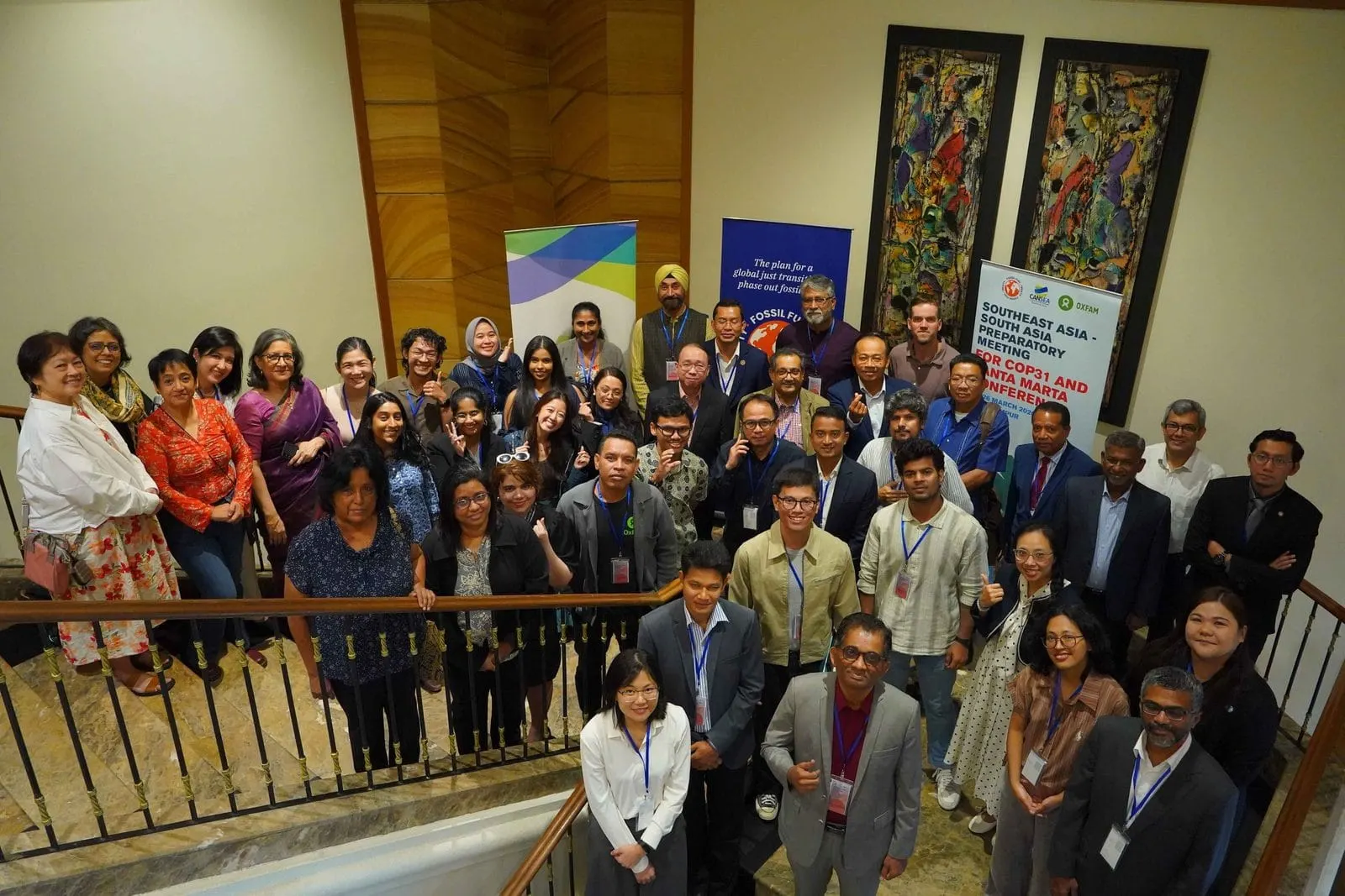 Civil-society delegates from Southeast and South Asia gathered on a staircase at the Kuala Lumpur preparatory meeting for COP31 and the Santa Marta conference
