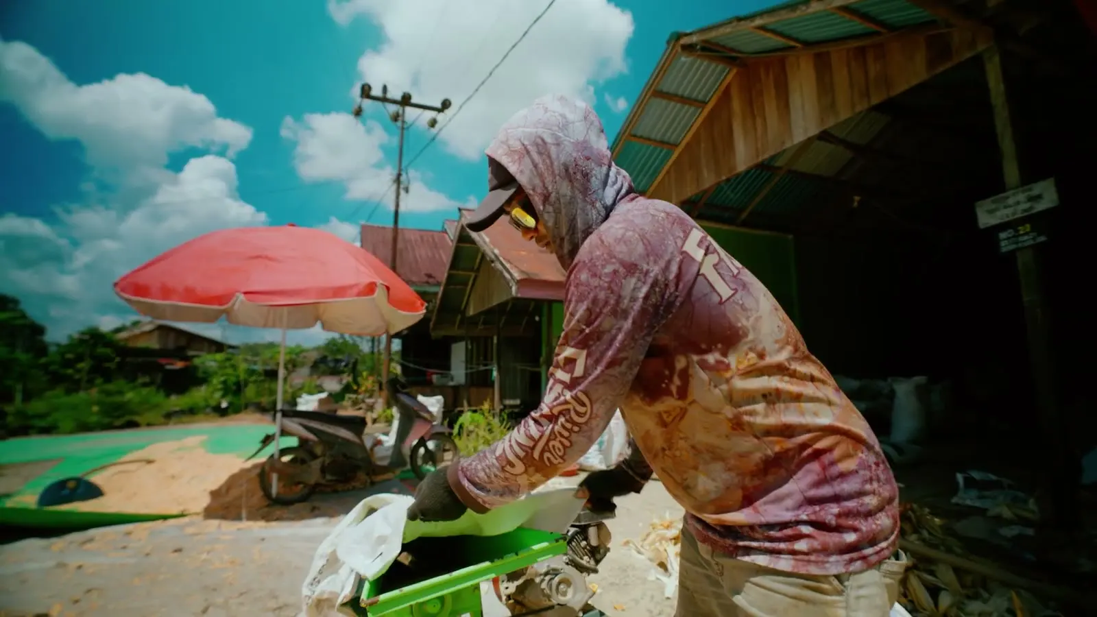 A worker in a hooded shirt at a roadside stall in East Kalimantan, from The Last Coal